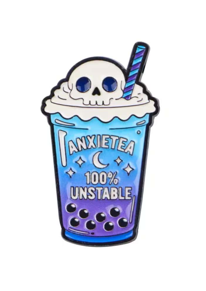 Ein farbiger boba tee enamel pin in blau-lila mit schädel im sahnehäubchen und gestreiftem strohhalm unstable shake gothic pin
