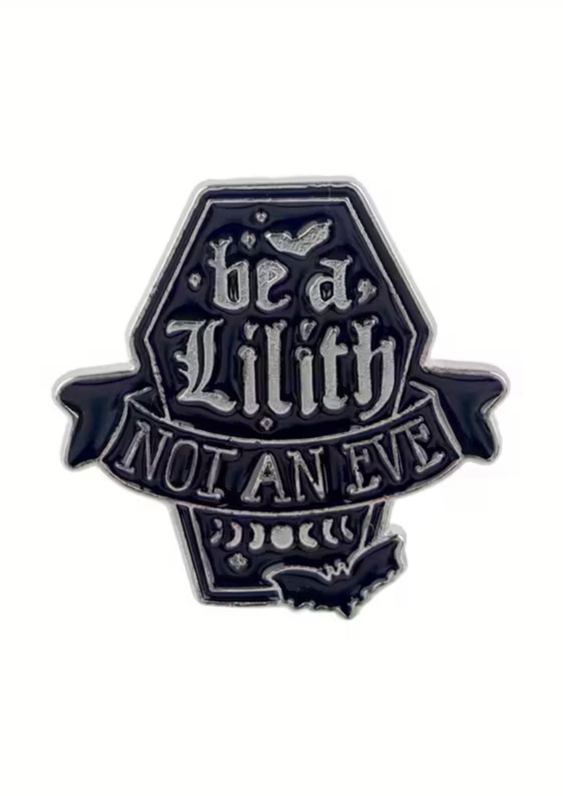 Schwarze Emaille-Anstecknadel in Form eines Sarges mit dem Text ’Be a Lilith not an Eve’.