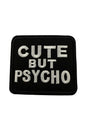 Schwarzer gestickter Aufnäher mit weißer Schrift ’CUTE BUT PSYCHO’.