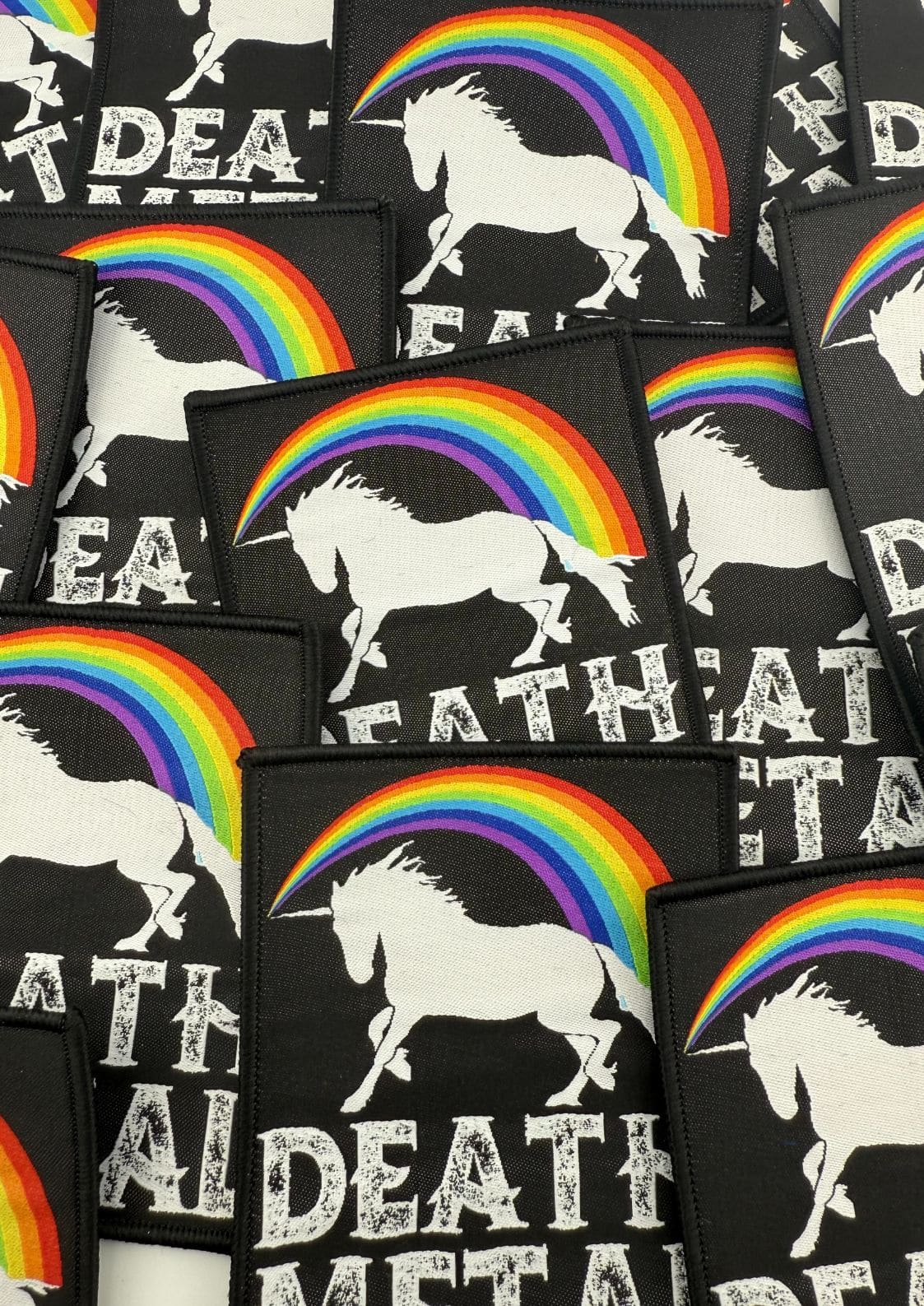 Schwarze Aufnäher mit einem weißen Einhorn und einer Regenbogengrafik