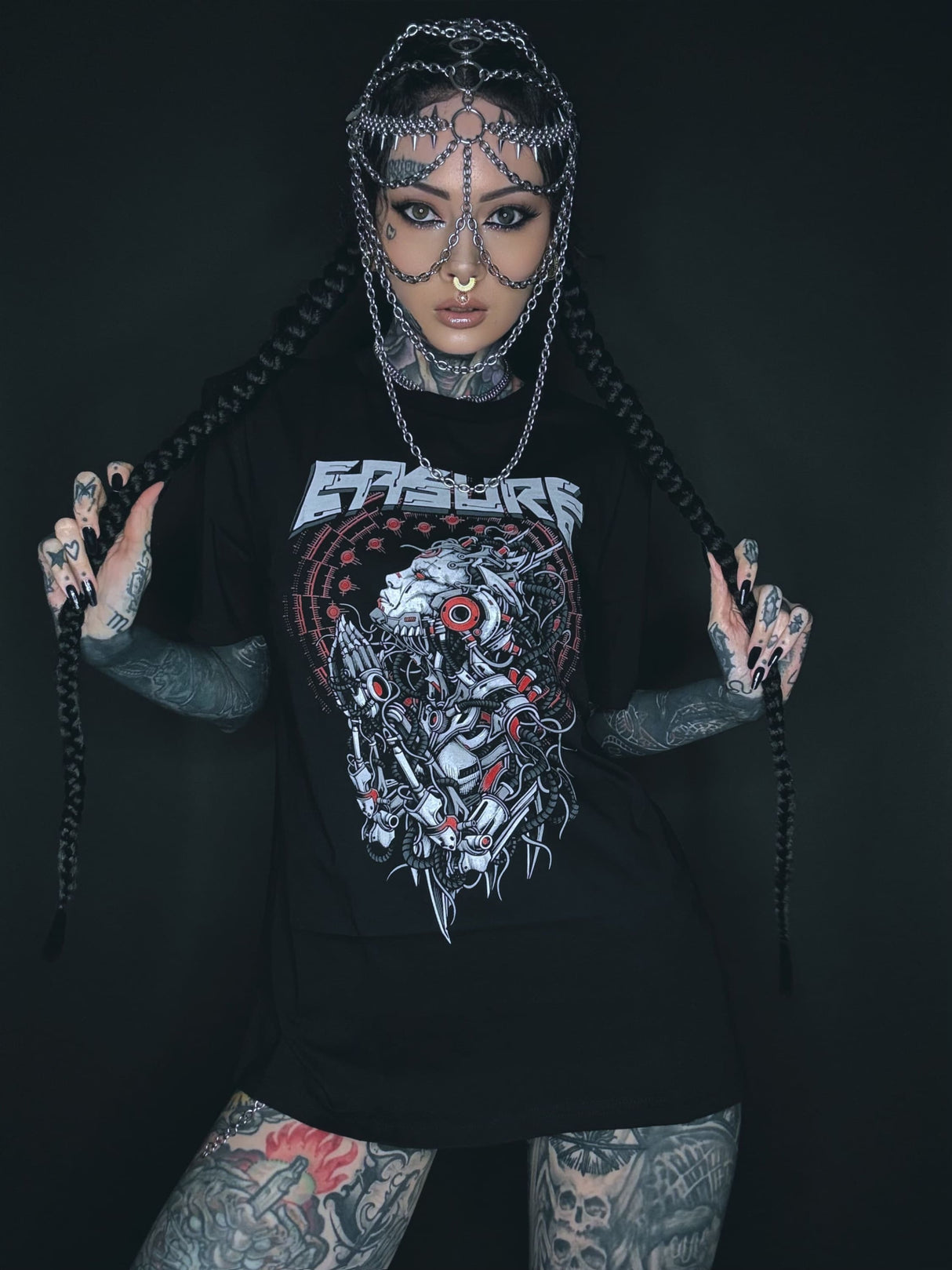 Tätowierte Frau mit Kettenkopfbedeckung und grafischem T-Shirt.