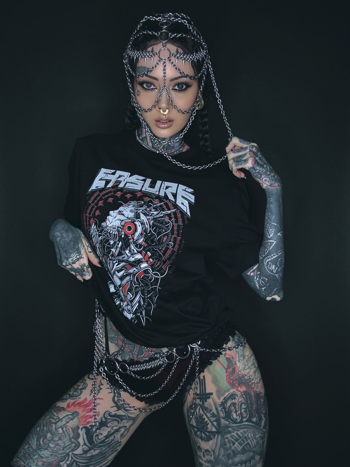 Tätowierte Frau mit Kettenkopfbedeckung und T-Shirt.