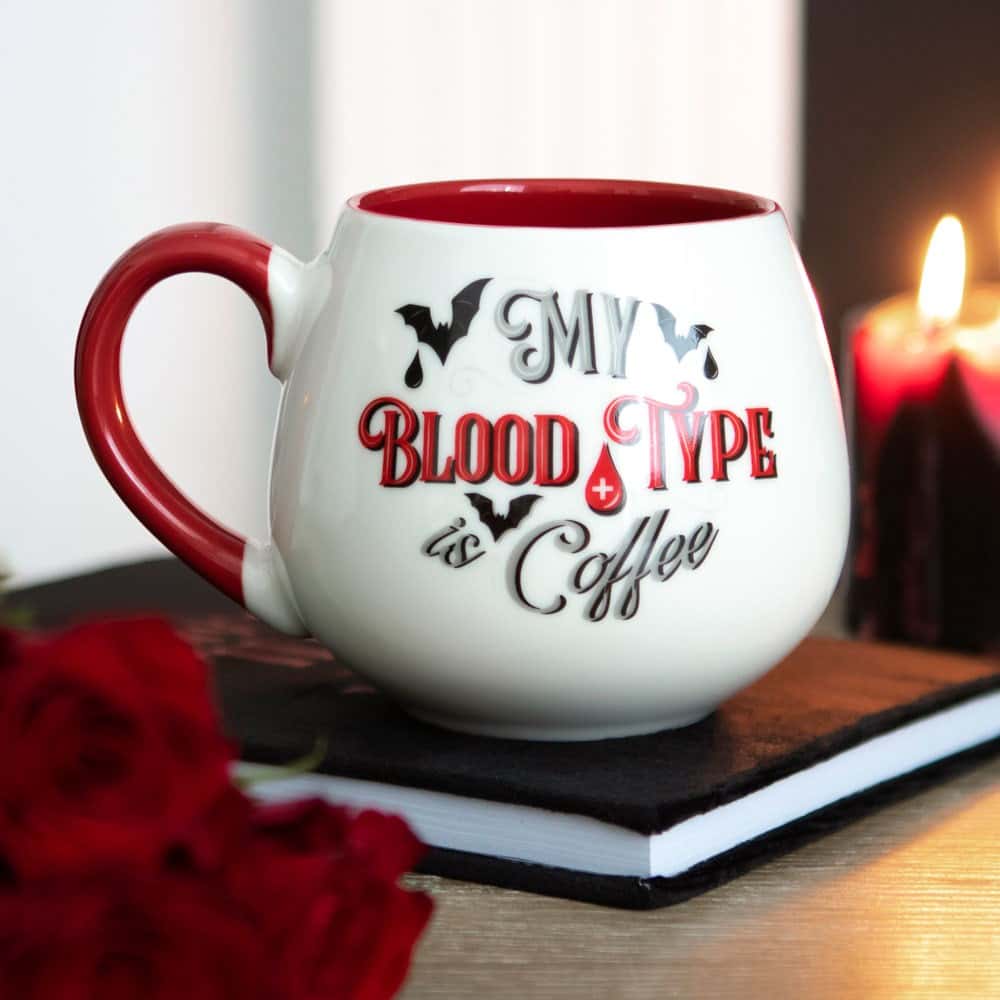 Weiße keramik kaffetasse mit rotem griff und innen, mit aufdruck mein bluttyp ist coffee und schattierungen von fledermäusen