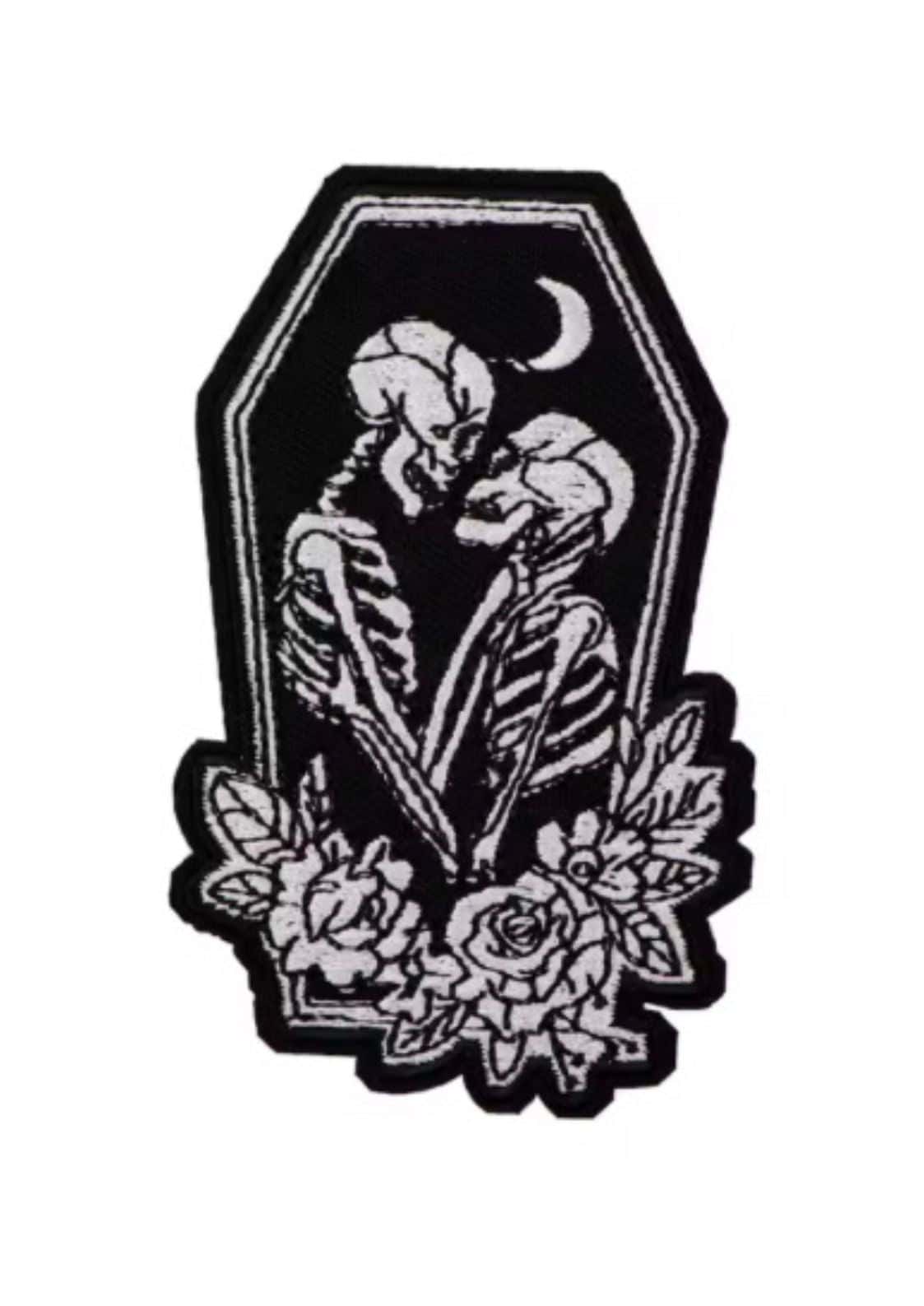 Schwarzweiß bestickter patch mit skelett coffin motiv zeigt zwei umarmende rückgratfiguren mit rosen im gothic horror stil