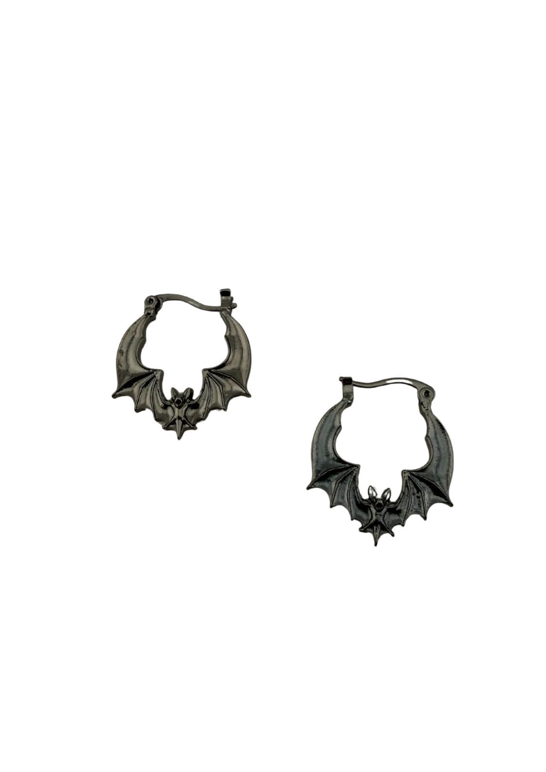 Zwei dunkle, silberfarbene, fledermausförmige Ohrringe.