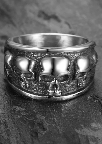 Ein breiter silberner ring mit drei detaillierten schädel sarg motive als gothic schmuck