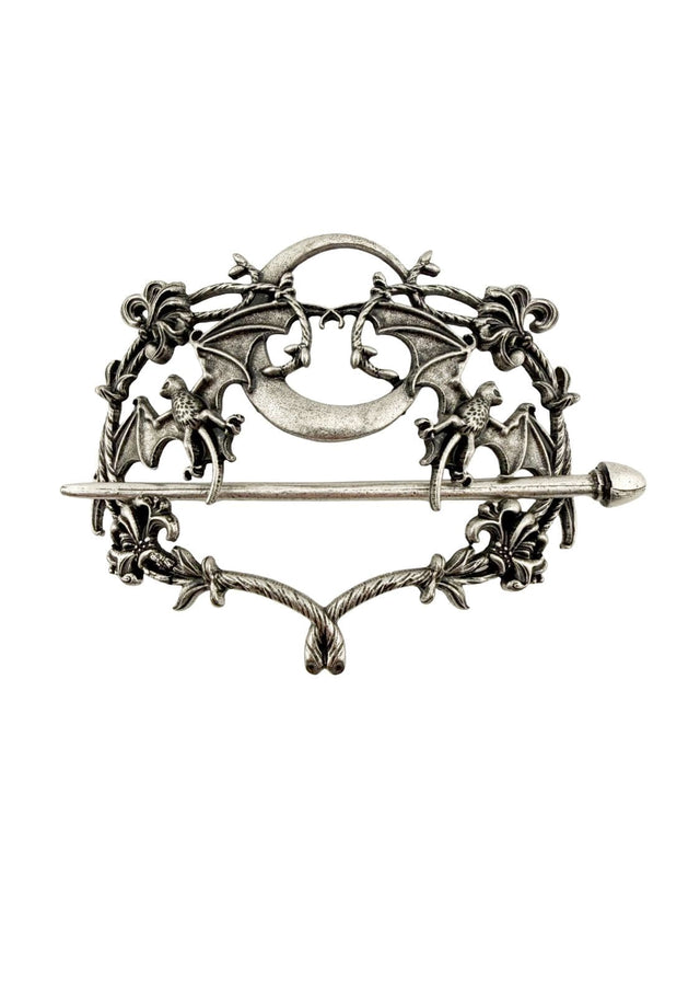 Silberfarbene Metallbrosche mit aufwendigen Fledermaus- und Blumenmustern um einen zentralen Halbmond.