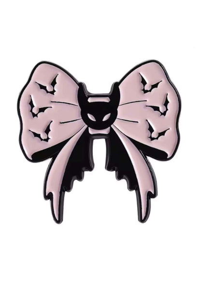 Rosa und schwarz emaillierte Anstecknadel in Form einer Schleife mit Fledermausmotiven.