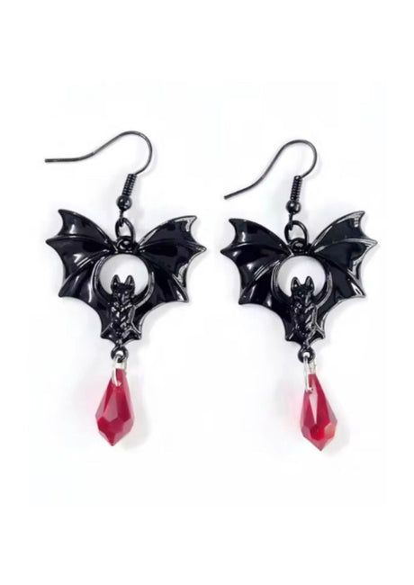 Fledermausförmige Ohrringe mit roten Kristalltropfen, schwarzen und silbernen Akzenten.