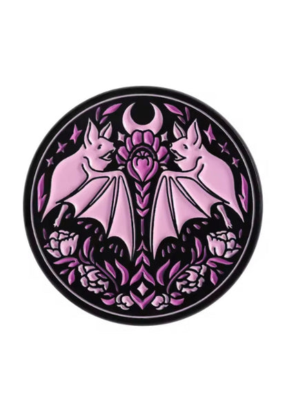 Rosa Emaille-Anstecknadel in Form einer Fledermaus mit violetter Lotusblume und Mondsichelmotiv.