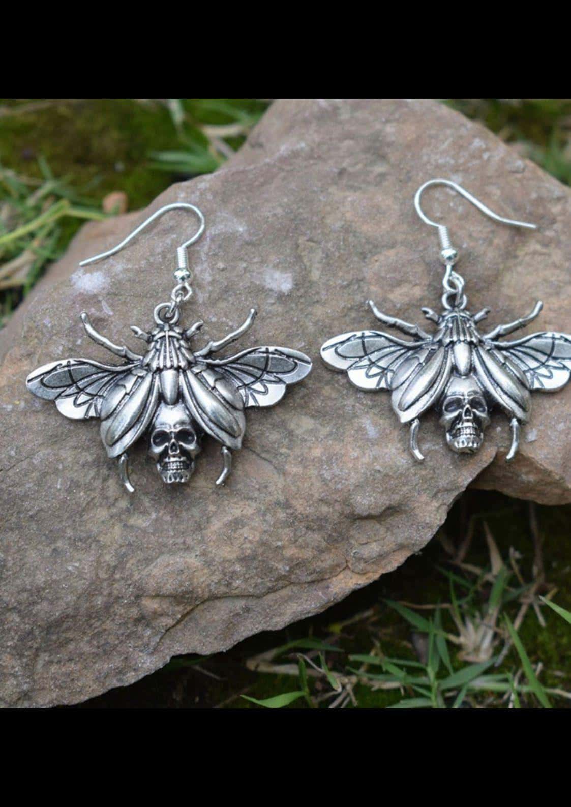 Silberne beetle skull ohrringe aus metalllegierung mit detaillierten flügeln und schädel für gothic und dark fashion