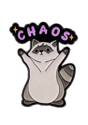 Waschbärförmiges Emaille-Pin mit »Chaos«-Schriftzug und Sternen, lila Akzente auf weißem Hintergrund.