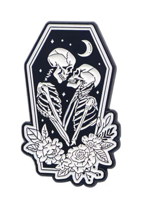 Skelettbrosche mit floralen Akzenten und Sargrahmen, schwarzer Hintergrund.