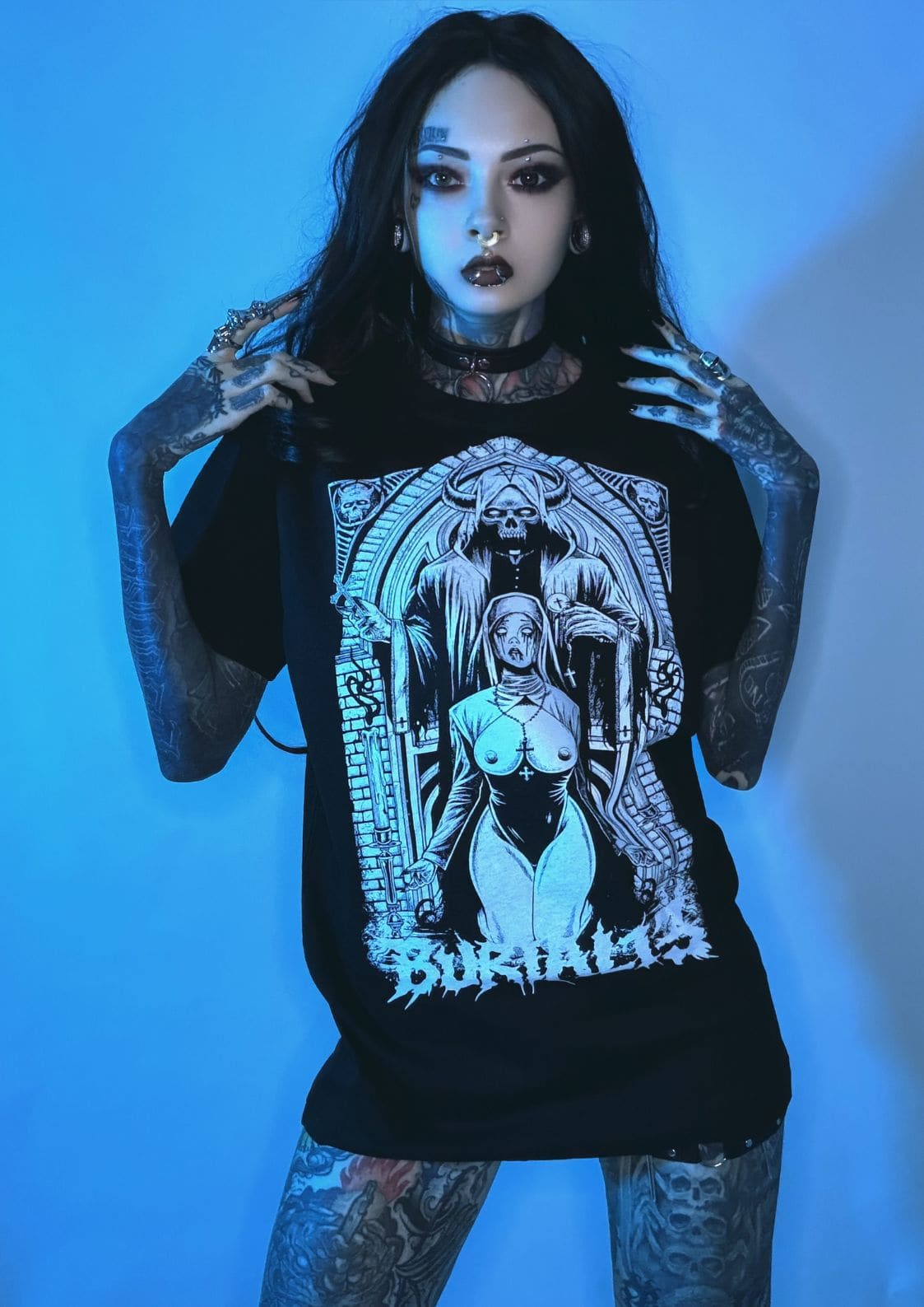 Schwarzes Graphic-T-Shirt mit einer detaillierten weißen Illustration einer skelettierten Figur in einem ornamentalen Bogen mit dem Wort „Begräbnisse“ darunter gedruckt.