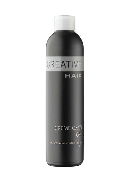 Eine schlanke schwarze flasche kreative haarcreme entwickler h2o2 creme oxyd 3 % mit weißem deckel und silbernem etikett