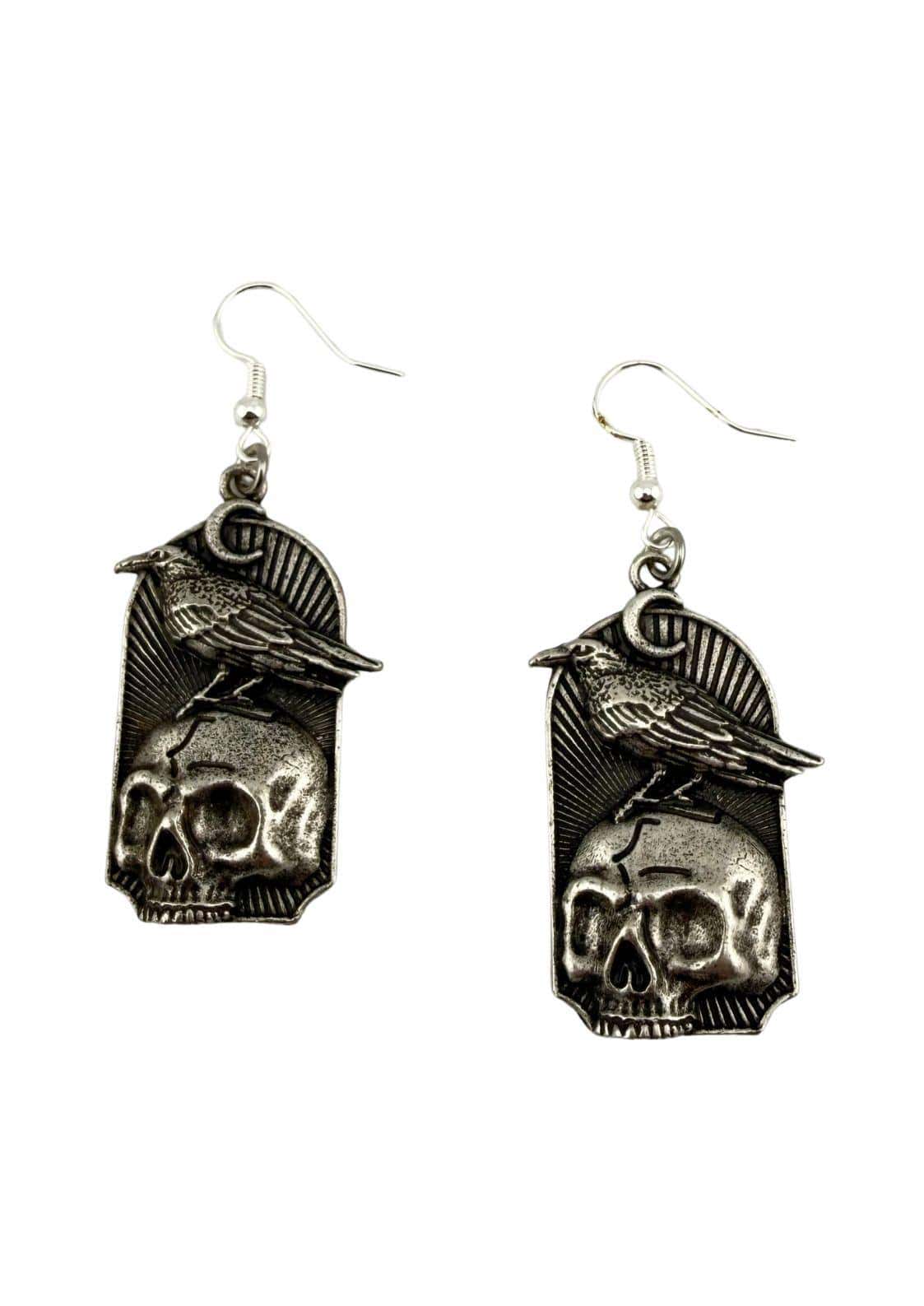 Silberfarbene gothic ohrringe mit detailliertem design eines krähens auf schädel im bogenrahmen mit strahlen
