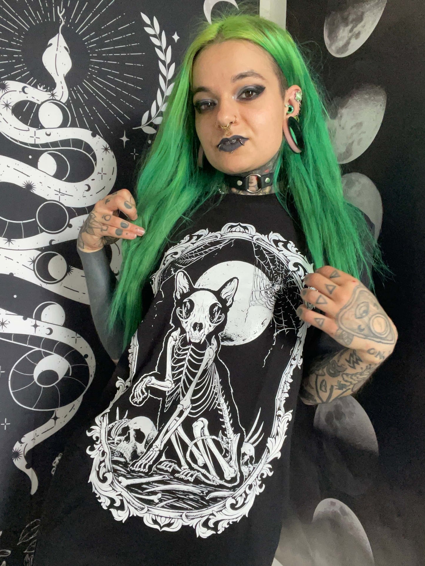 Schwarzes gothic t-shirt mit weißem grafikprint eines skelettkatze unter mond und ornamentalen details für horror fans