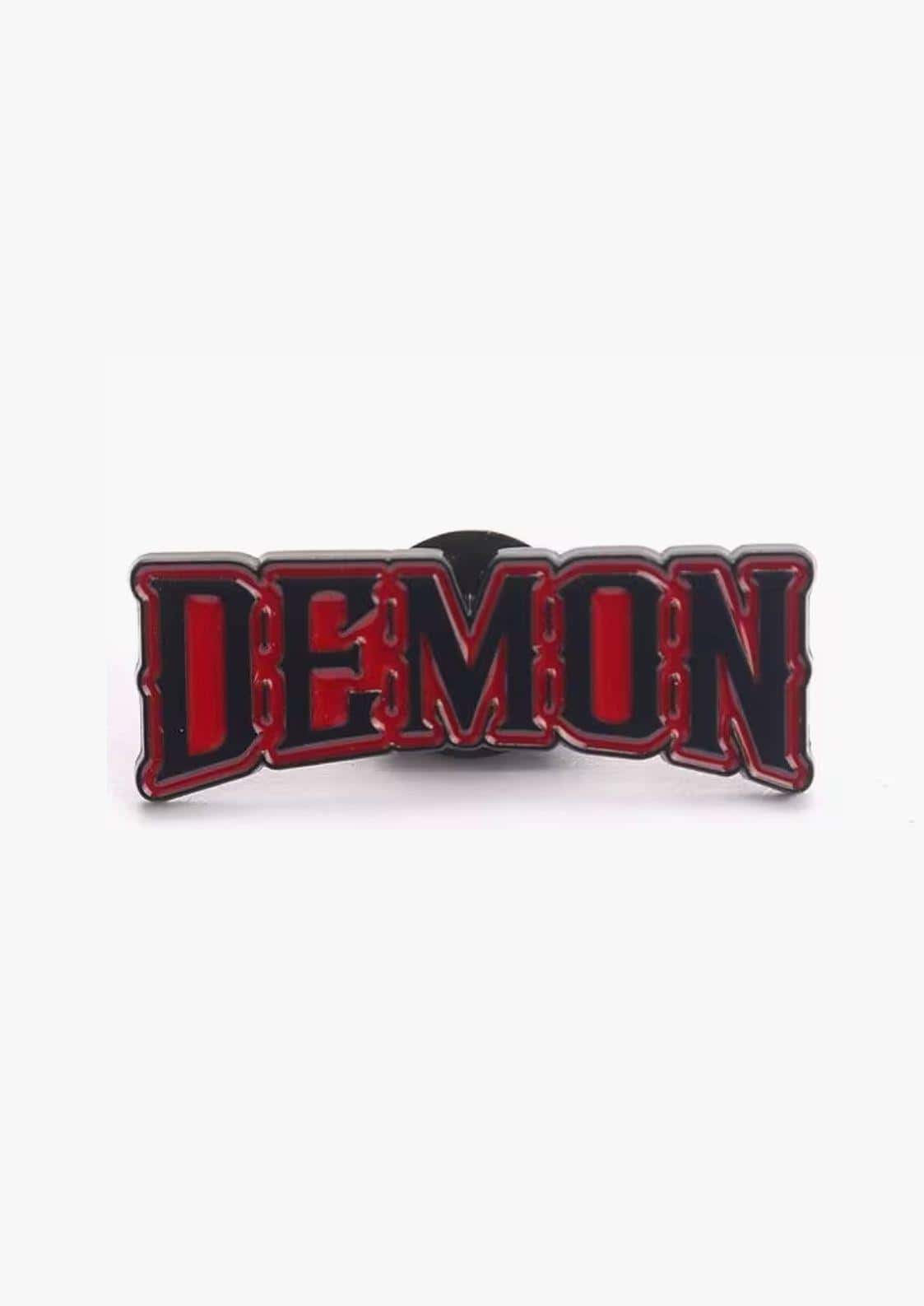 Red and black enamel pin with demon in bold arched lettering perfect for gothic horror dark fashion styles