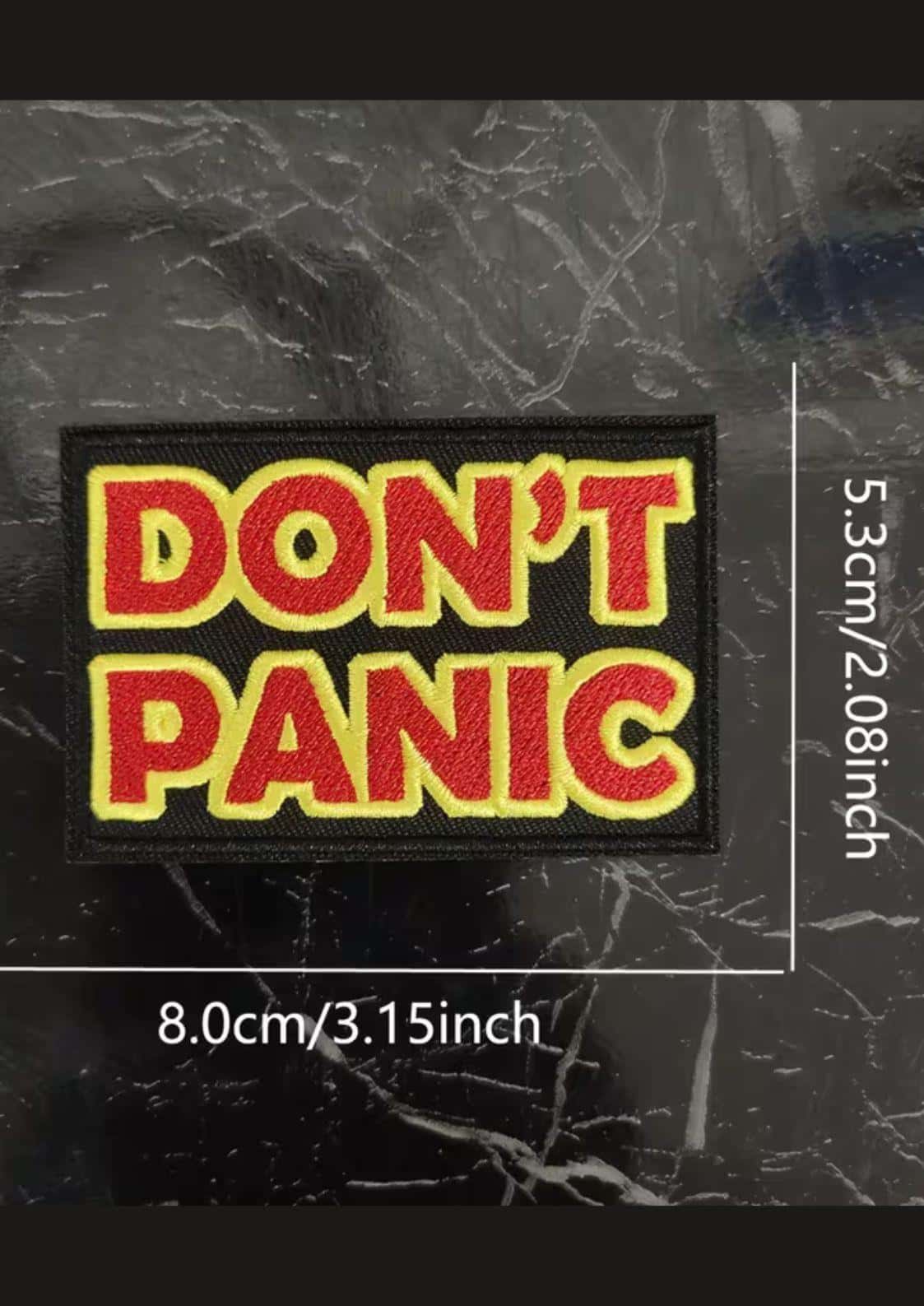 Ein rechteckiger bestickter patch mit roten gothic buchstaben don´t panic auf schwarzem stoff für gothic kleidung