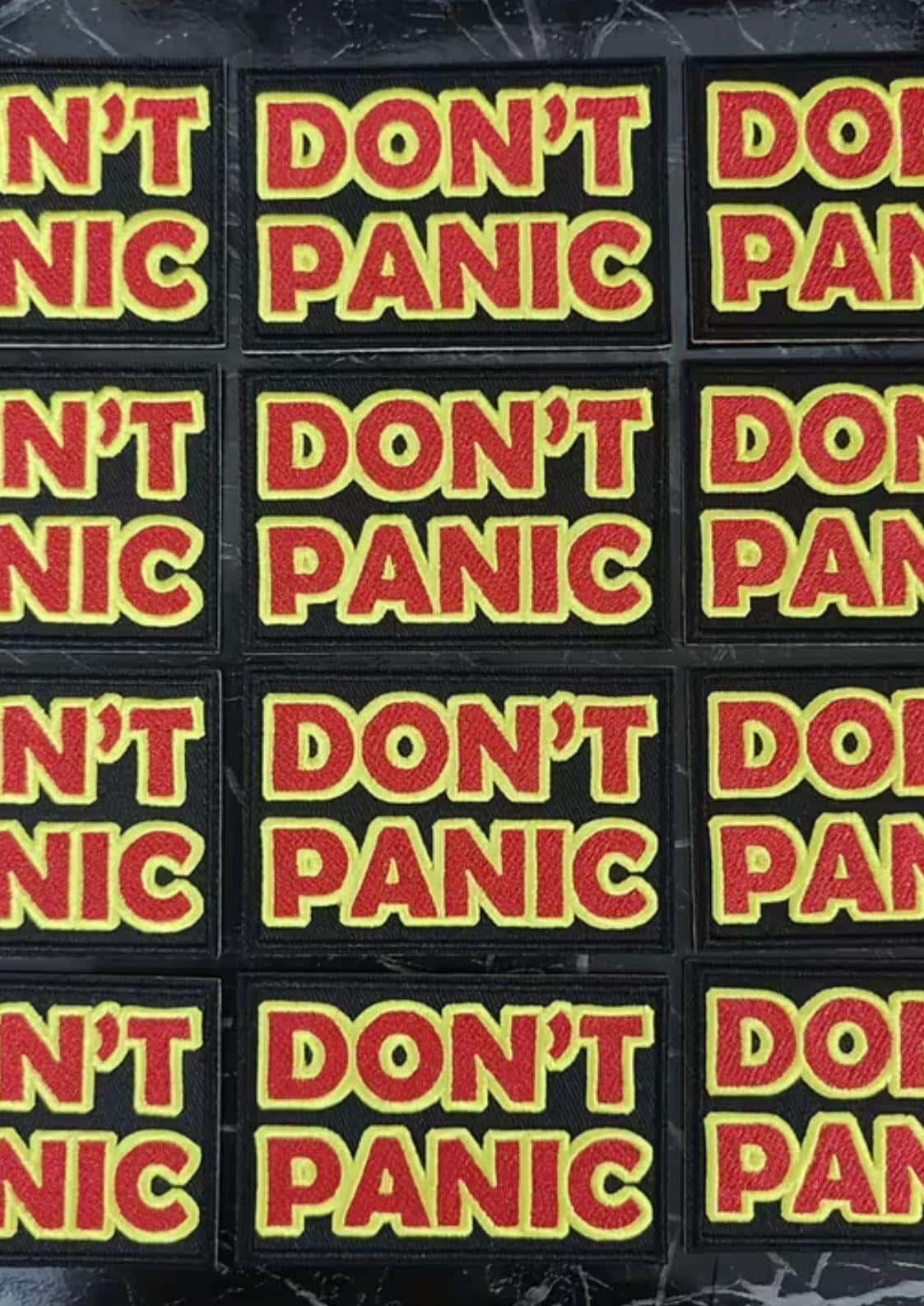 Schwarze bestickte patch mit fettem roten und gelben don´t panic text, ideal für gothic und dark fashion fans