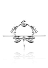 Silberne Libellenspange mit filigranen Flügeln, einem Halbmond darüber und korallenartigen Ästen zu beiden Seiten.