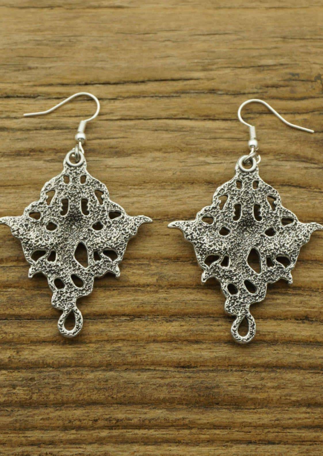 Silberne dragonheads ohrringe mit filigranem spitzenmuster und strukturierter oberfläche für gothic und dark fashion