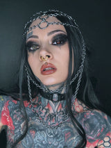 Tätowierte Frau mit Kettenkopfbedeckung und Halsband.