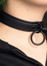 Schwarzes Lederhalsband mit Metallring.
