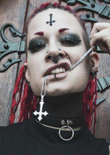 Gothic-Frau mit Piercings und umgedrehtem Kreuz.