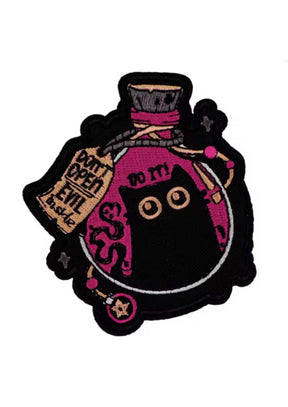 Ein gestickter Aufnäher, der eine schwarze Katze in einem Gefäß zeigt.