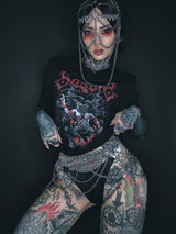 Ein schwarzes Grafik-T-Shirt mit einem rot-weißen dämonischen Design, das das Wort ‚something‘ in stilisierten Buchstaben über einer aufwendigen Illustration zeigt.