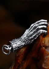 Silberner anhänger in handförmiger Form mit aufwendigen Schnitzereien und einer kleinen Öse zum Befestigen an Schmuck.