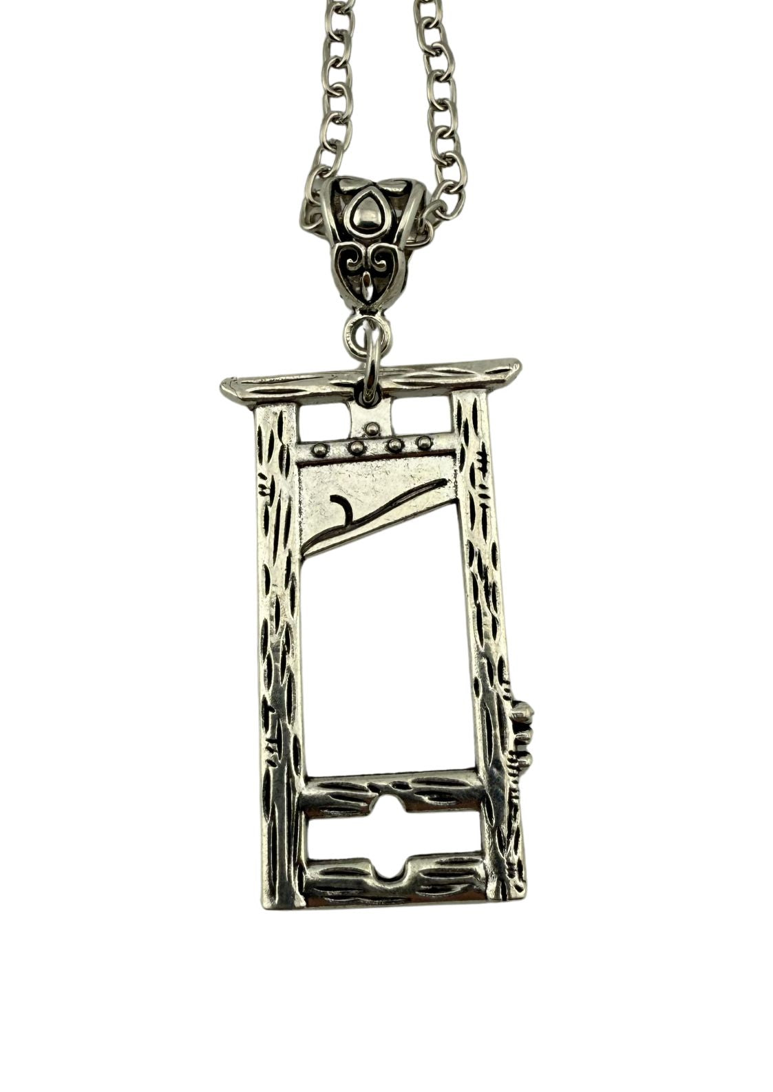 Ein silberfarbener Metallanhänger in Form einer Miniatur-Guillotine, der an einer Kette befestigt ist.