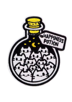 Ein gestickter Aufnäher mit einer Flasche voller Cartoon-Katzen und dem Etikett ’Happiness Potion’.