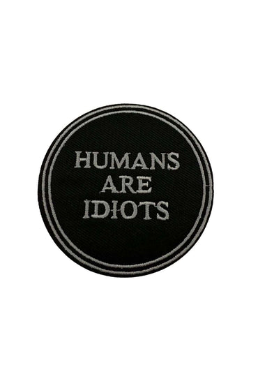 Rundes schwarzes patch mit weißer stickerei humans are idiots in klarer schrift