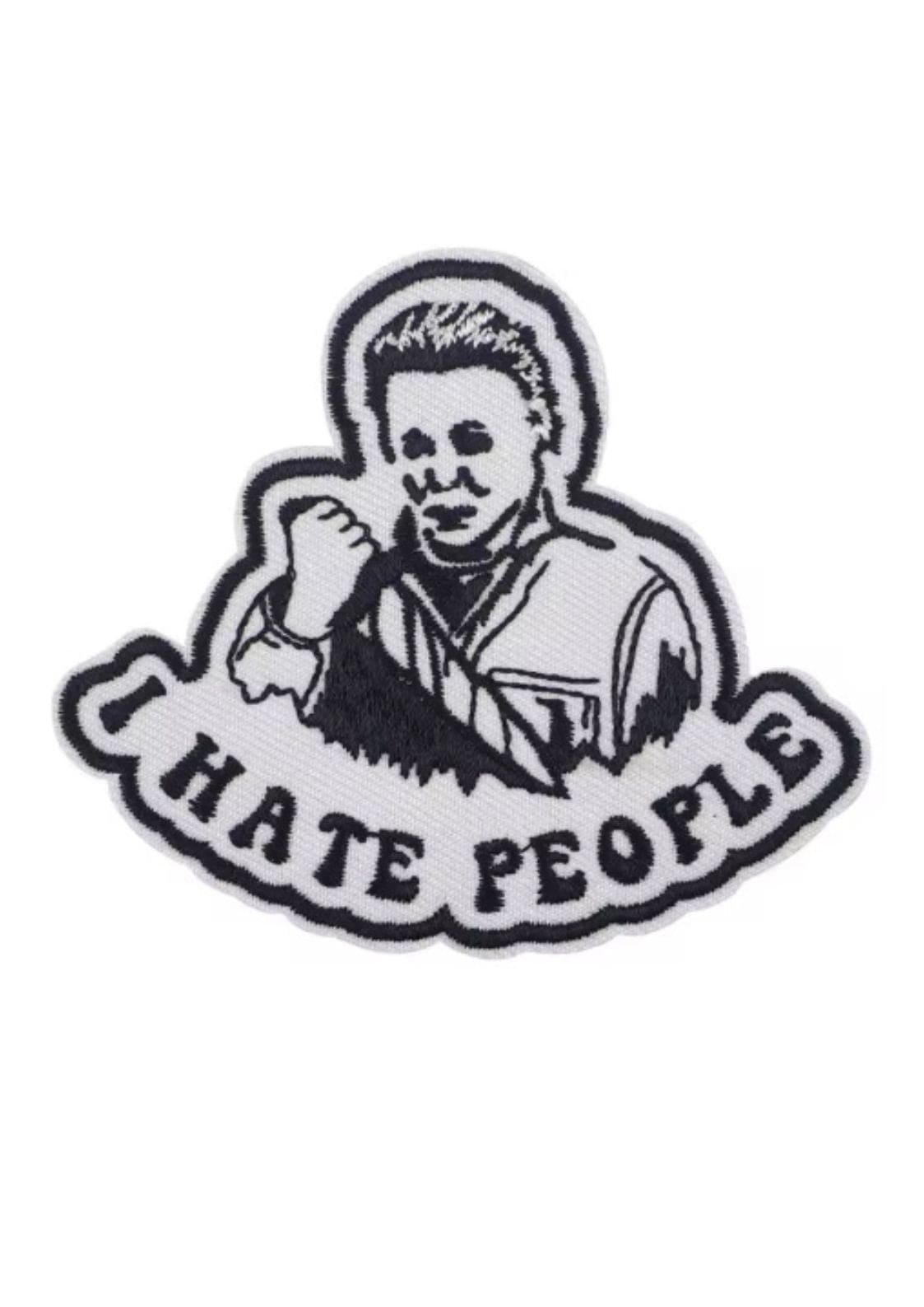 Weißer und schwarzer gestickter Aufnäher mit einer Person, die ein Messer hält, und dem Text ’I HATE PEOPLE’.