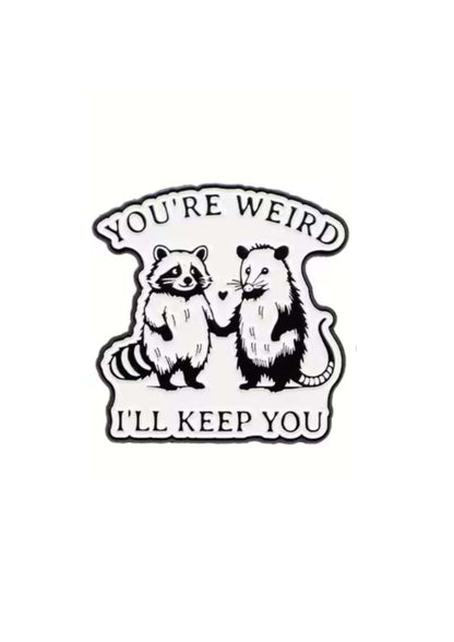 Schwarz-weiß Emaille-Anstecker mit zwei Waschbären und Opossum, die Händchen halten, Text „you’re weird i’ll keep you“, Produkt ILL KEEP YOU - PIN