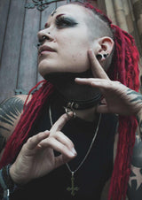 Gothic-Frau mit roten Dreadlocks und Tattoos.