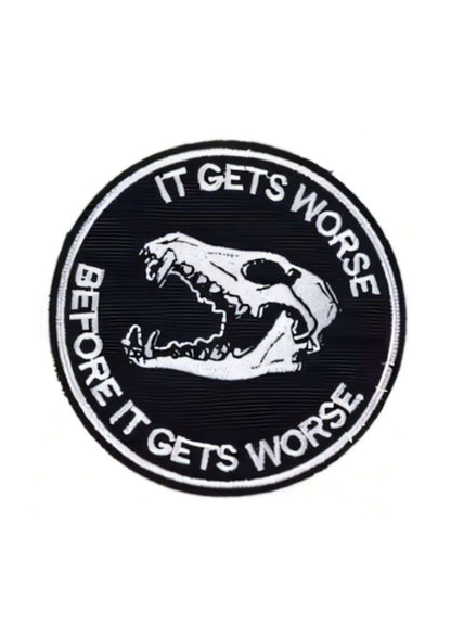 Schwarzer runder stoffpatch mit weißem besticktem schädel und dem slogan it gets worse before it gets worse als gothic patch