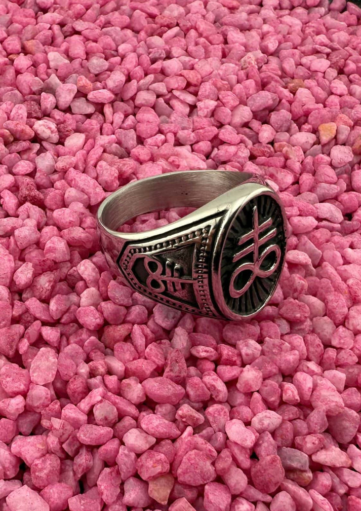 Silberner leviathan ring aus edelstahl mit schwarzem design und text auf rosa kies in china gefertigt