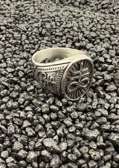 Silberner, verzierten Ring mit Blumenmuster auf schwarzem Lavafelsen-Hintergrund.