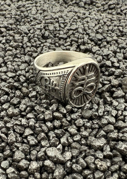 Silberner, verzierten Ring mit Blumenmuster auf schwarzem Lavafelsen-Hintergrund.