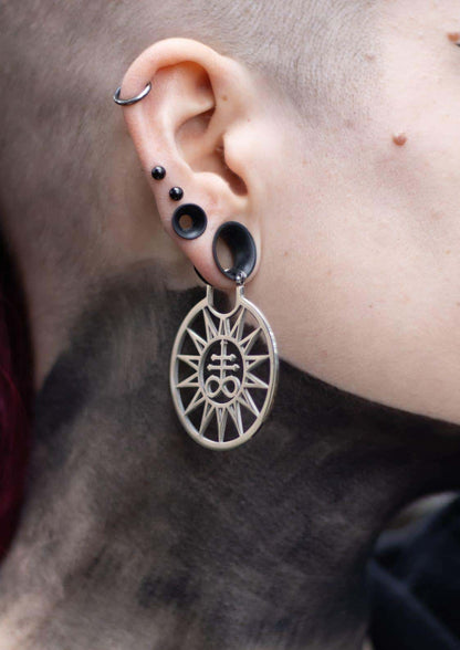 Silberne leviathan sun ohrringe mit ovaler sonnenstrahlgestaltung und okkultem symbol, schwarze silikon plugs, gothic horror style