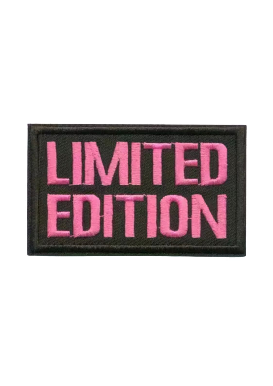 Limitierte Edition-Aufnäher mit geprägtem pinkem Text auf schwarzem Hintergrund.
