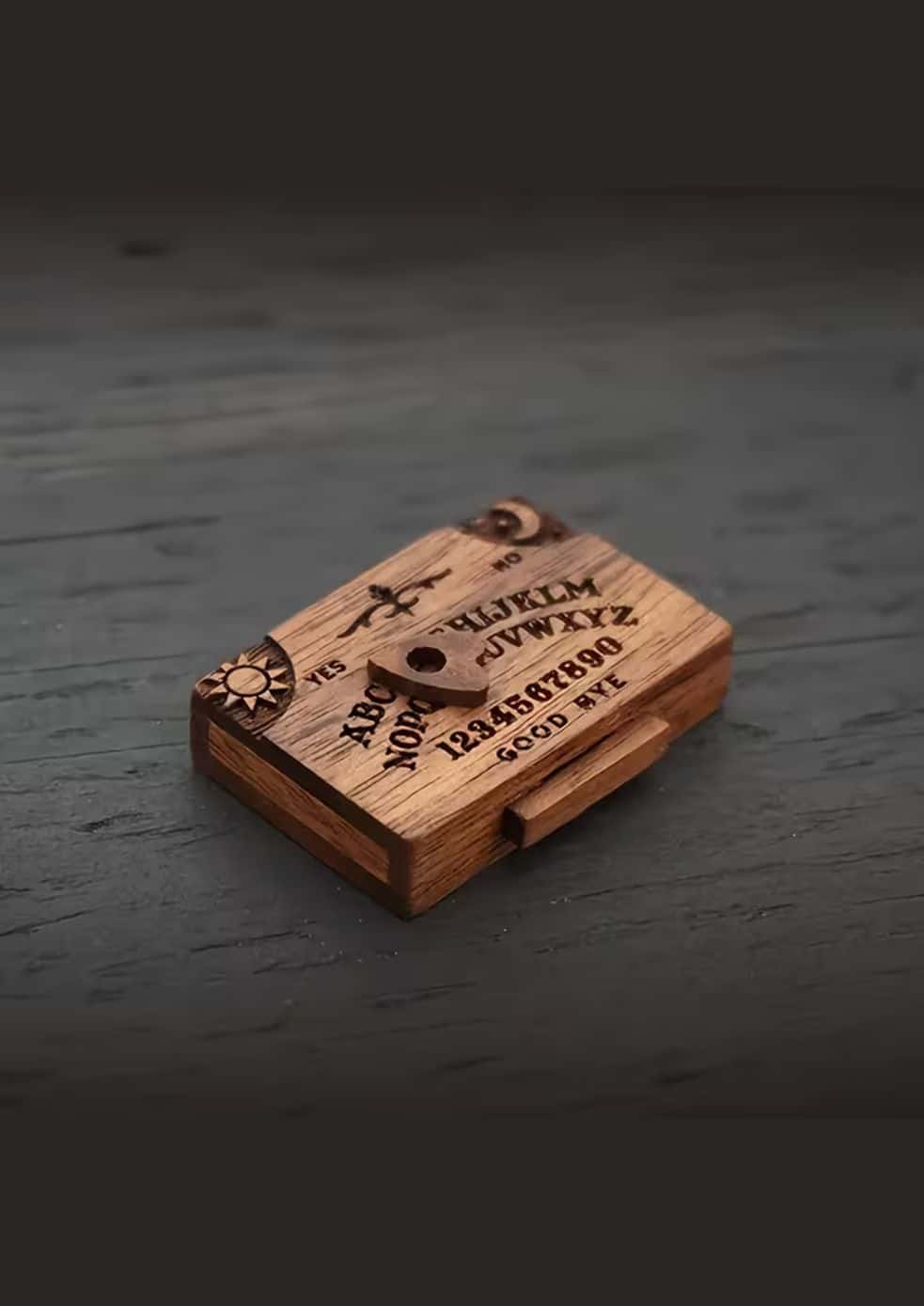 Ein kompaktes Holz-Wiijaboard mit gravierten Buchstaben, Zahlen und Symbolen auf seiner Oberfläche.