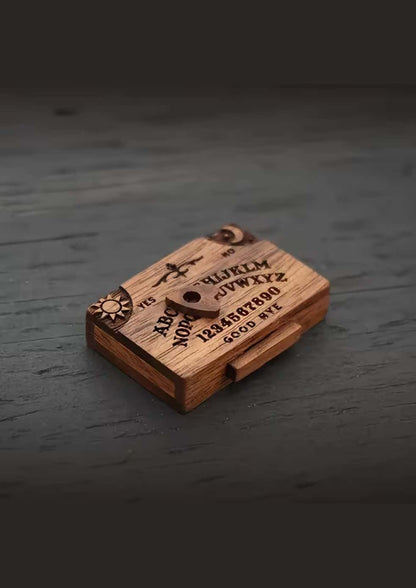 Ein kompaktes Holz-Wiijaboard mit gravierten Buchstaben, Zahlen und Symbolen auf seiner Oberfläche.