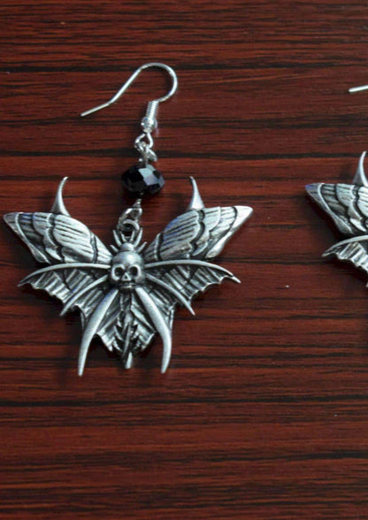 Silberne schmetterlingsförmige ohrringe mit schädelmotiv und schwarzem perlenakzent für gothic und dark fashion