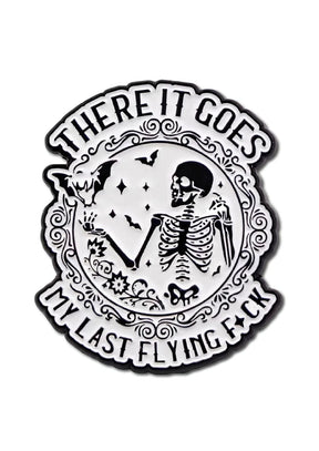 Weiß-schwarze Emaille-Anstecknadel mit einem Skelett und Fledermäusen.