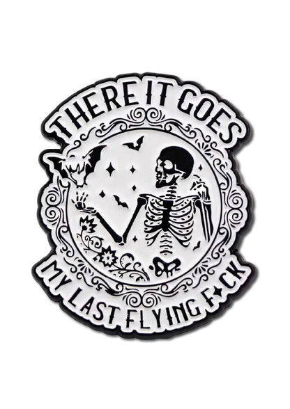 Weiß-schwarze Emaille-Anstecknadel mit einem Skelett und Fledermäusen.