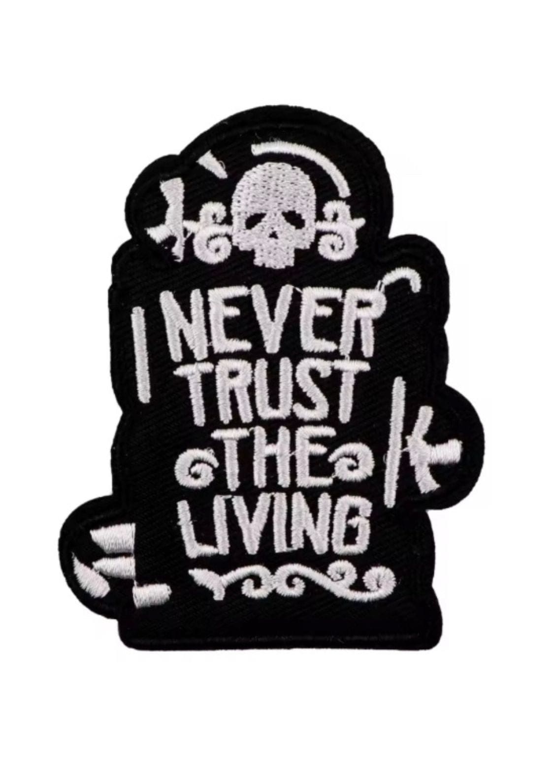 Schwarzer gestickter Aufnäher mit einem Totenkopf und der Aufschrift ’I NEVER TRUST THE LIVING’.